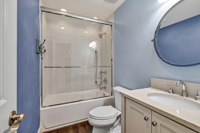 full bathroom with toilet, shower / bath combination with glass door, vanity, and wood finished floors