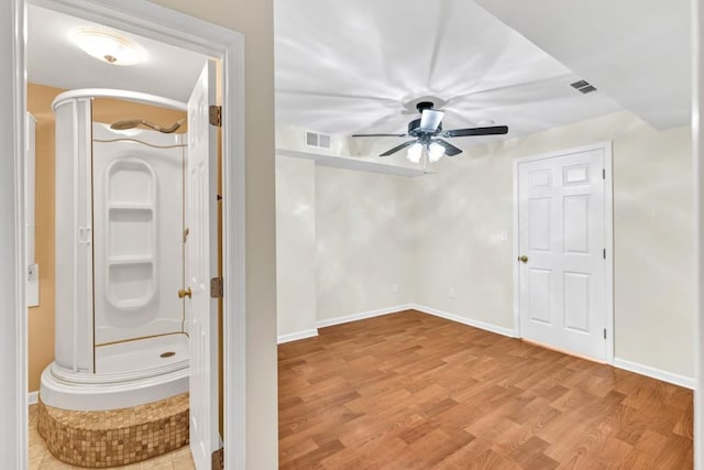 interior space featuring light wood finished floors, baseboards, visible vents, and a ceiling fan
