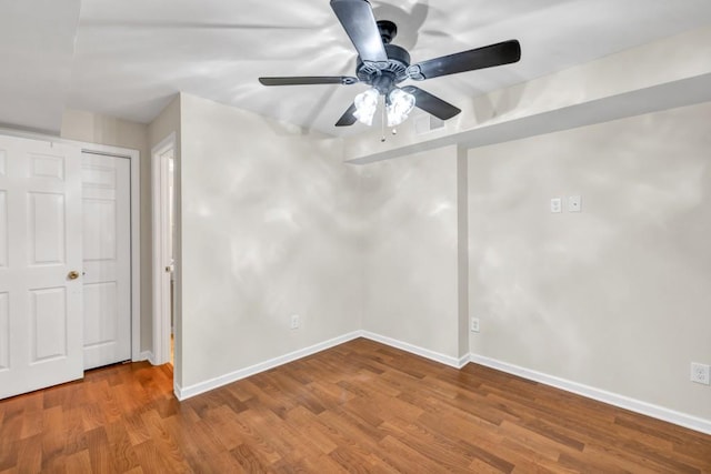 unfurnished bedroom featuring baseboards, wood finished floors, and a ceiling fan