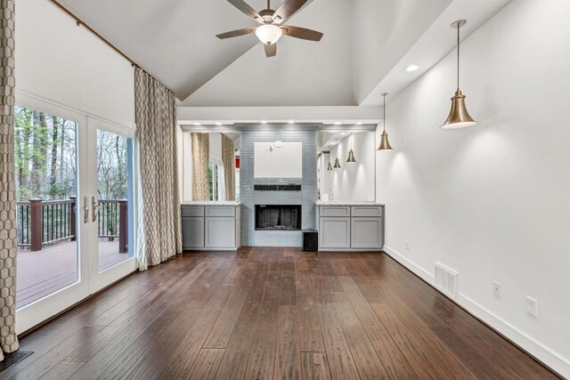 unfurnished living room with ceiling fan, high vaulted ceiling, french doors, and dark wood finished floors