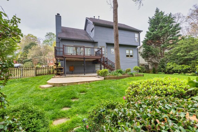back of house with fence, a wooden deck, a lawn, stairs, and a chimney