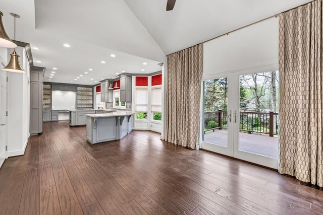 kitchen with french doors, a breakfast bar area, gray cabinetry, dark wood-style floors, and ceiling fan
