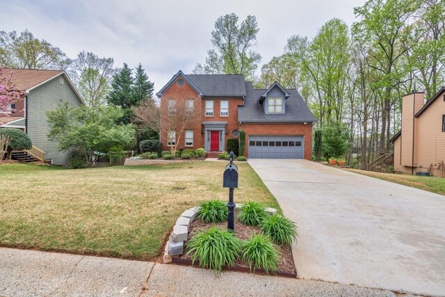 view of front of property featuring driveway, brick siding, a garage, and a front yard