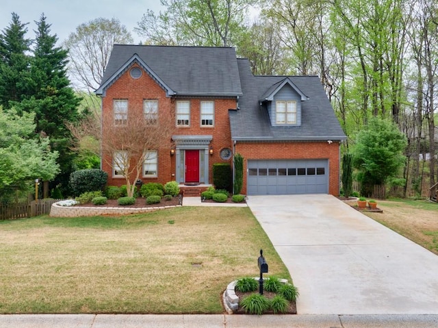 colonial inspired home featuring concrete driveway, fence, a front yard, brick siding, and a garage