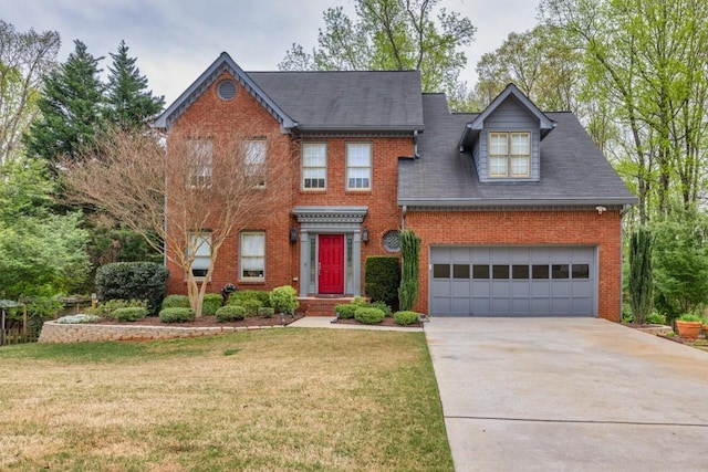 colonial house featuring brick siding, a front yard, and driveway