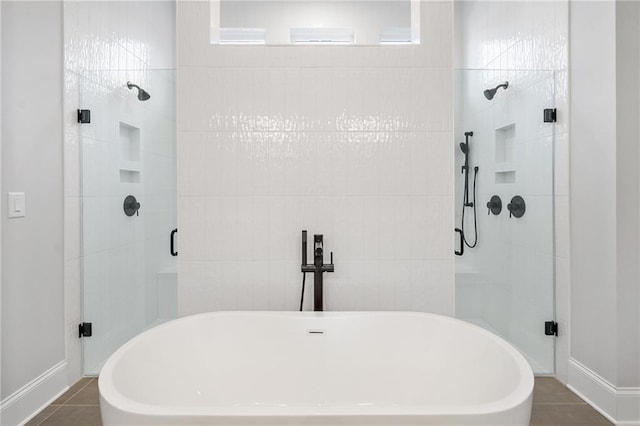 full bathroom featuring a stall shower, a soaking tub, and tile patterned flooring