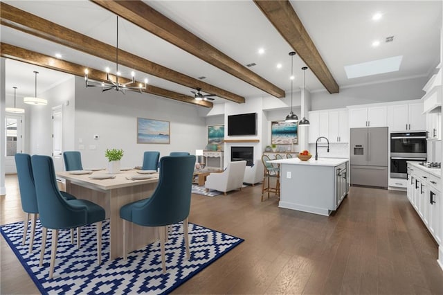 dining room featuring dark wood-type flooring, crown molding, a fireplace, and beamed ceiling