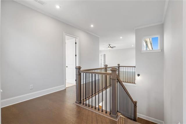 corridor with crown molding, wood finished floors, an upstairs landing, and baseboards