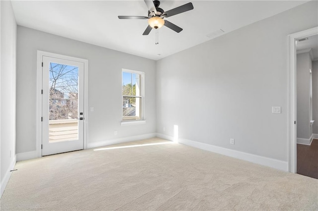 carpeted empty room with ceiling fan, visible vents, and baseboards