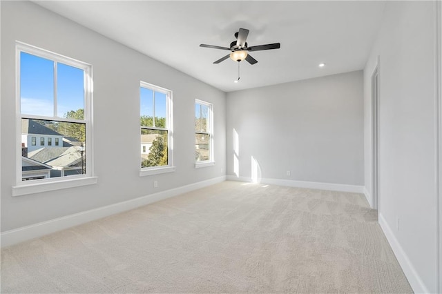 spare room featuring light carpet, ceiling fan, recessed lighting, and baseboards