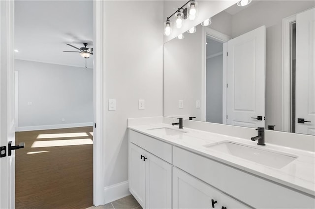 full bath with ceiling fan, a sink, baseboards, and double vanity