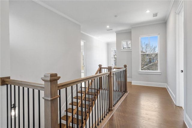 hall with crown molding, visible vents, an upstairs landing, wood finished floors, and baseboards