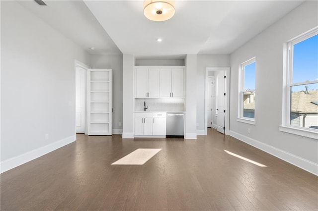 interior space featuring dark wood-type flooring, a sink, and baseboards