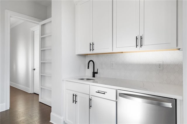 bar featuring dark wood finished floors, backsplash, a sink, dishwasher, and baseboards