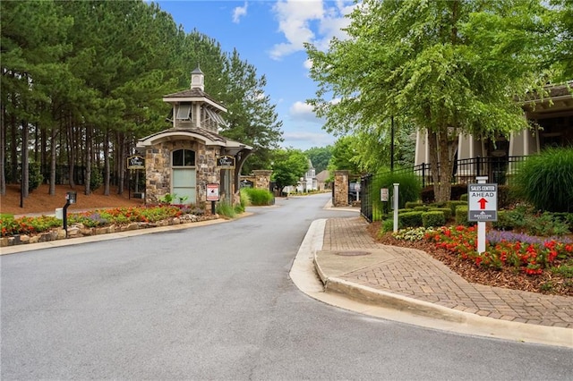 view of road featuring curbs and a gated entry