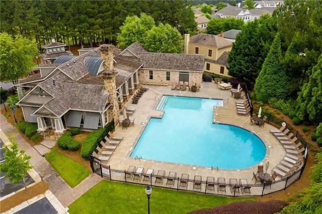 community pool featuring fence and a patio