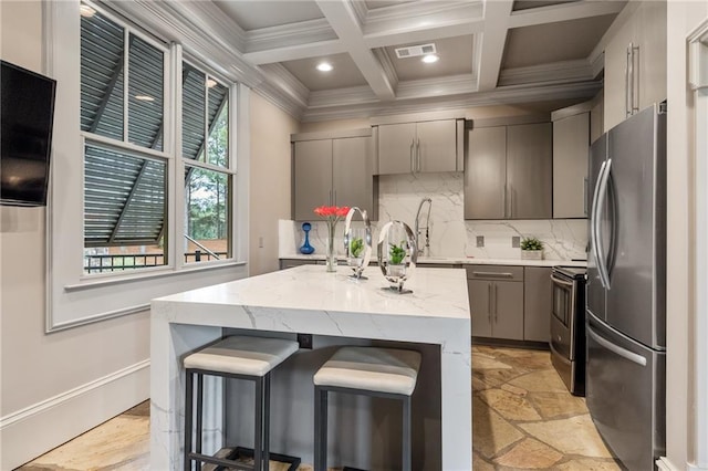 kitchen featuring stainless steel appliances, gray cabinets, ornamental molding, and beamed ceiling