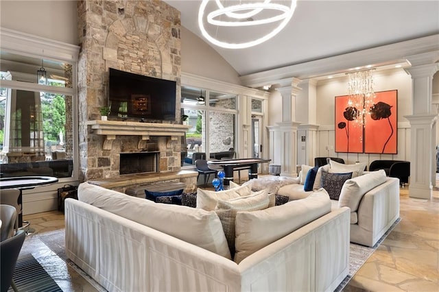 living room featuring high vaulted ceiling, a fireplace, and ornate columns