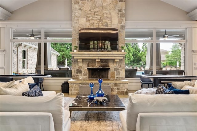 living room featuring lofted ceiling, a fireplace, and ceiling fan