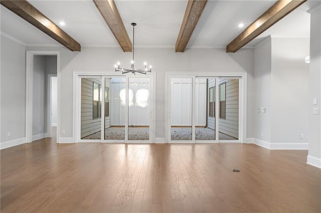 interior space with an inviting chandelier, beamed ceiling, baseboards, and wood finished floors