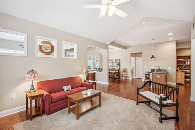 living room with hardwood / wood-style floors, ceiling fan, lofted ceiling, and sink