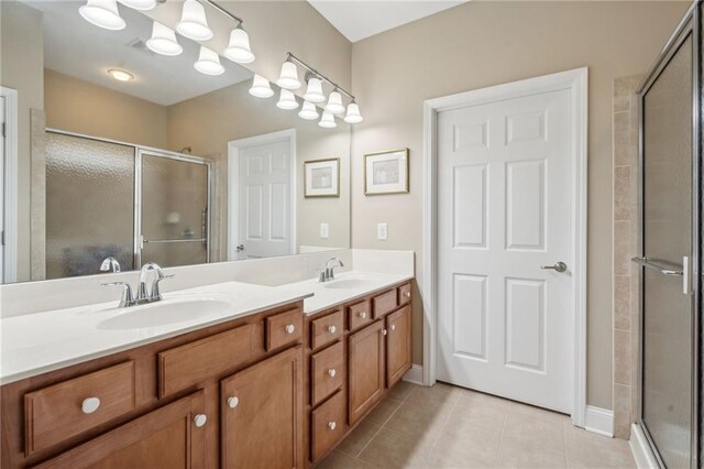 bathroom with tile patterned floors, vanity, and an enclosed shower