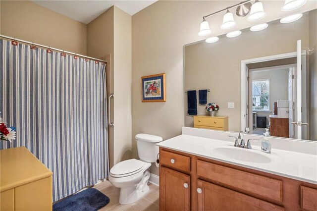 bathroom with tile patterned flooring, vanity, and toilet