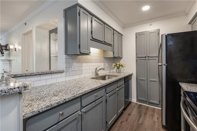 kitchen featuring appliances with stainless steel finishes, ornamental molding, sink, gray cabinets, and dark hardwood / wood-style floors