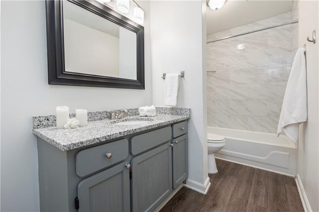 full bathroom with vanity, toilet, wood-type flooring, and tiled shower / bath