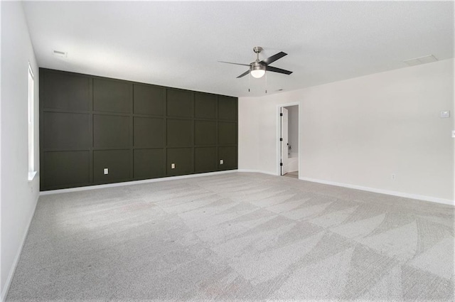 carpeted spare room with baseboards and a ceiling fan