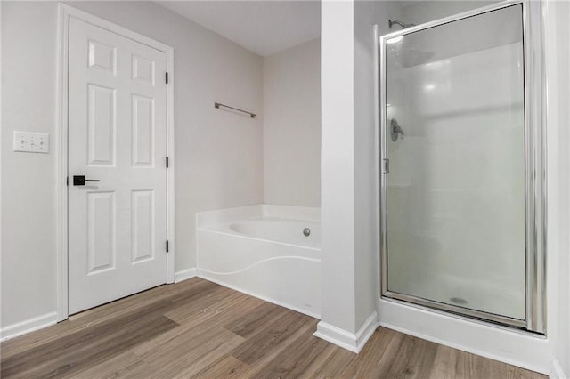 full bathroom featuring a garden tub, wood finished floors, and a shower stall