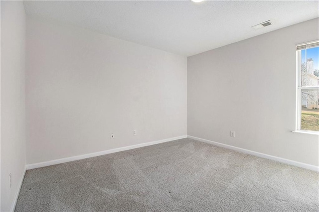 unfurnished room featuring baseboards, a textured ceiling, visible vents, and carpet flooring