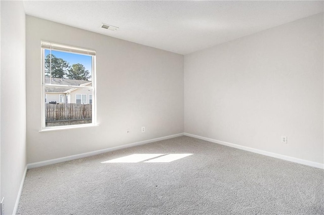 carpeted empty room with visible vents and baseboards