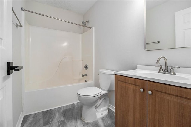 full bath featuring bathing tub / shower combination, vanity, toilet, and baseboards