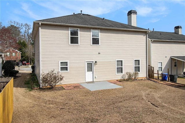 back of property with a patio area, a chimney, and fence