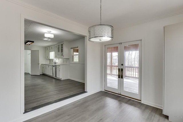 unfurnished dining area with french doors, baseboards, dark wood finished floors, and crown molding