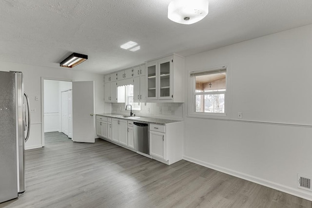 kitchen featuring a sink, visible vents, appliances with stainless steel finishes, and light wood-style flooring