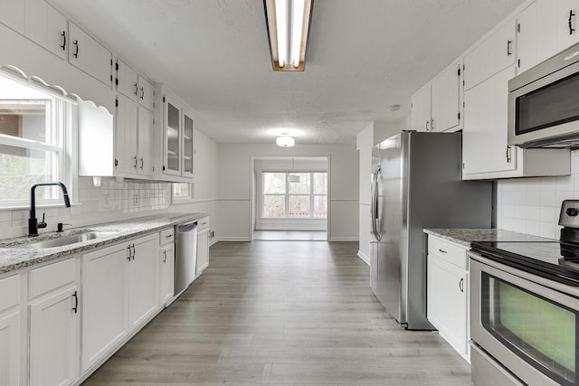 kitchen featuring a sink, appliances with stainless steel finishes, and white cabinets