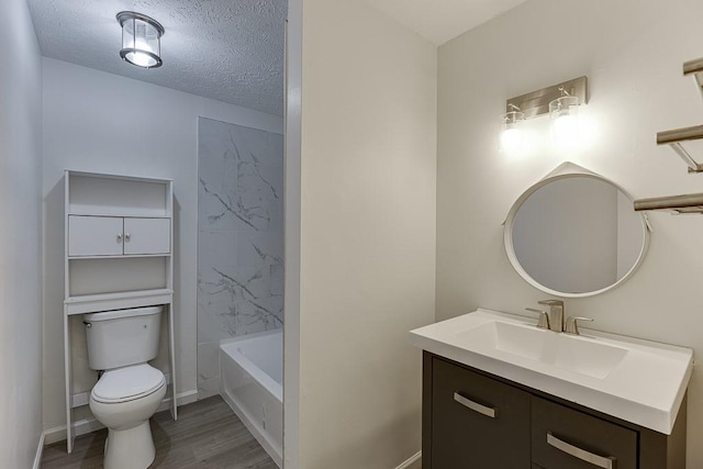 full bath with vanity, wood finished floors, baseboards, a textured ceiling, and toilet