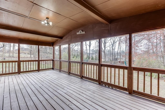 unfurnished sunroom featuring lofted ceiling with beams