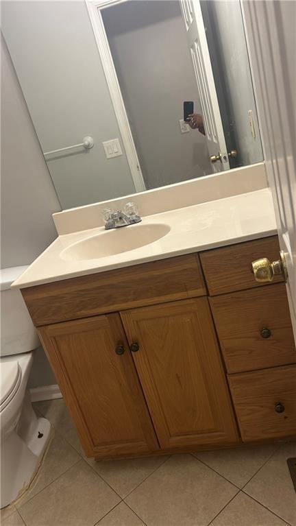 half bath with tile patterned floors, vanity, and toilet