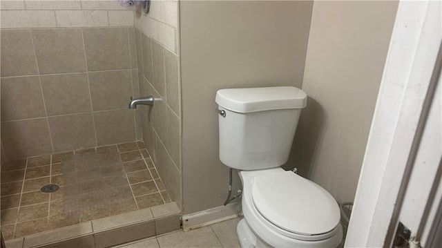 full bath with a stall shower, toilet, tile patterned floors, and baseboards