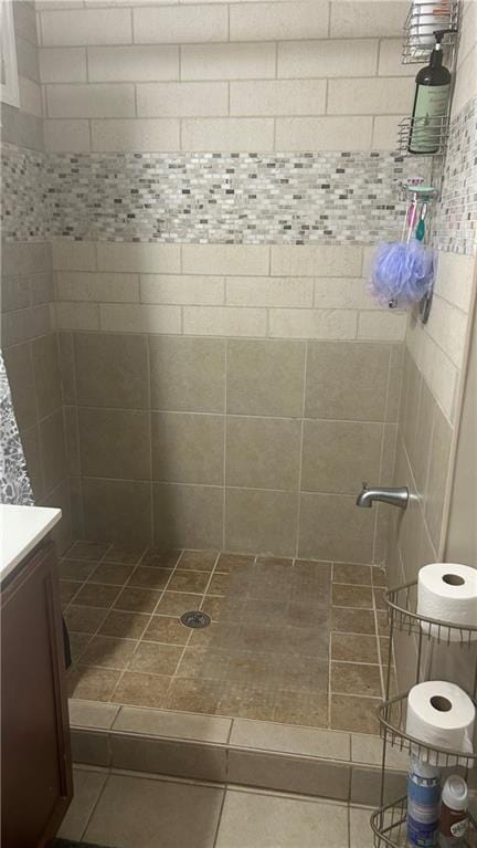 bathroom featuring tiled shower and vanity