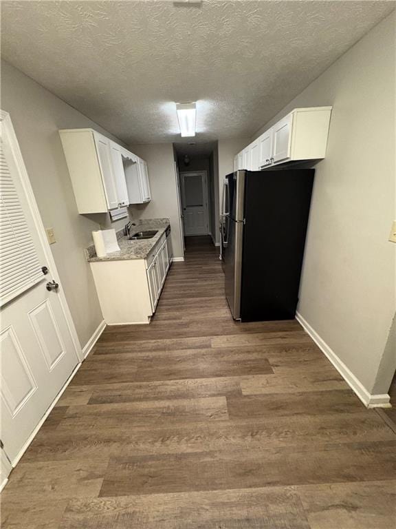 9161 Fairway Ct, Riverdale, GA 30274 - kitchen featuring a sink, dark wood-type flooring, baseboards, white cabinets, and freestanding refrigerator