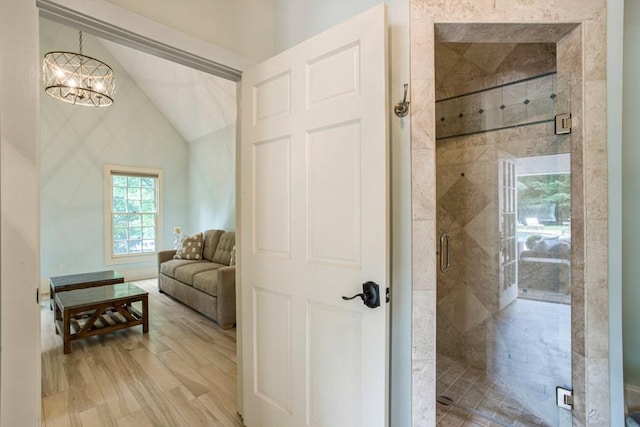 bathroom featuring a chandelier, an enclosed shower, vaulted ceiling, and hardwood / wood-style flooring