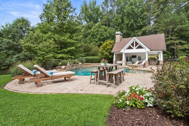 view of swimming pool with an outdoor structure, a yard, and a patio area