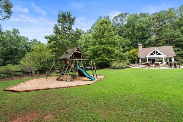 view of playground featuring a patio and a yard