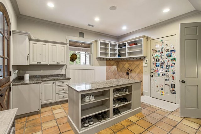 kitchen with white cabinetry, dark stone counters, refrigerator, and decorative backsplash