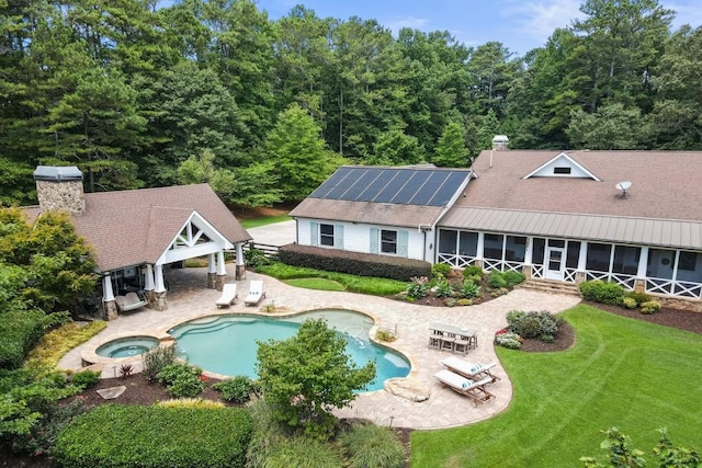 view of pool with an in ground hot tub, a patio, a sunroom, and a lawn