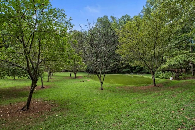 surrounding community featuring a lawn and a water view